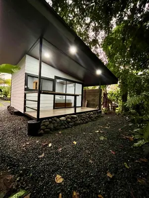 a small white house with windows on the side of it at Arenal Rocks in Fortuna