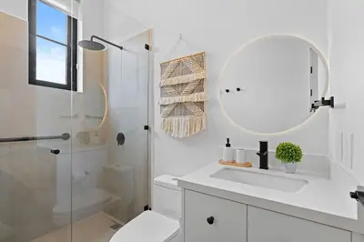 a white bathroom with a sink and a mirror at Sophisticated Modern Home with Ocean Views, Gorgeous Master Suites & Private Jacuzzi in Playa Danta