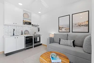 a living room with a gray couch and a kitchen at Sophisticated Modern Home with Ocean Views, Gorgeous Master Suites & Private Jacuzzi in Playa Danta