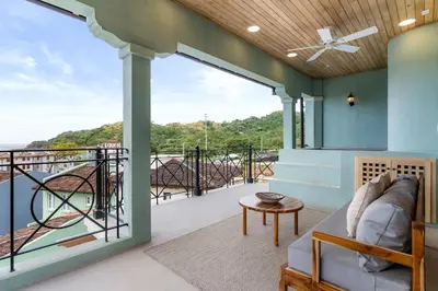 a living room with a couch on a balcony at Sophisticated Modern Home with Ocean Views, Gorgeous Master Suites & Private Jacuzzi in Playa Danta