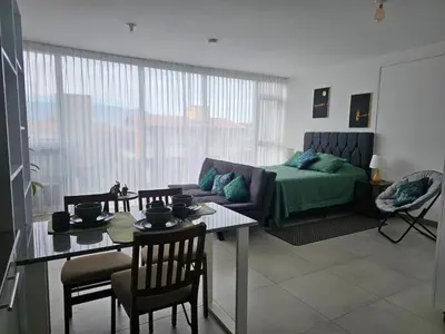 a living room with a couch and a table at Tropical Vista iFreses, 2nd floor! AC, TV and Pool in Guayabos