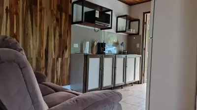 a living room with a couch and a kitchen at Casa Elora in Bagaces