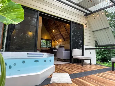 a bath tub sitting on a deck next to a house at River Paradise Cabin with Private Jacuzzi in Fortuna