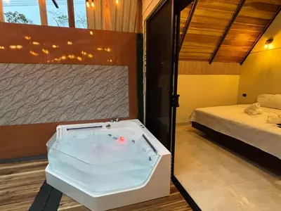 a bath tub in a room with a bed at River Paradise Cabin with Private Jacuzzi in Fortuna