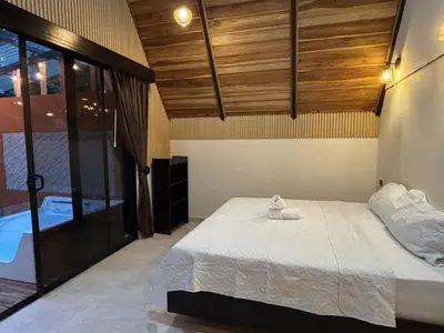 a bedroom with a large bed and a tub at River Paradise Cabin with Private Jacuzzi in Fortuna