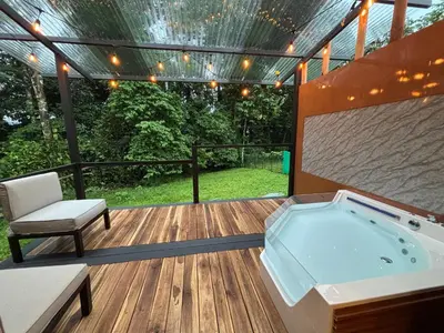 a hot tub on a deck with a pergola at River Paradise Cabin with Private Jacuzzi in Fortuna