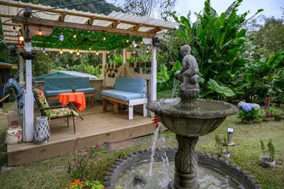 a fountain in a garden with a pergola at Blue Morpho Lodge in Bajos del Toro