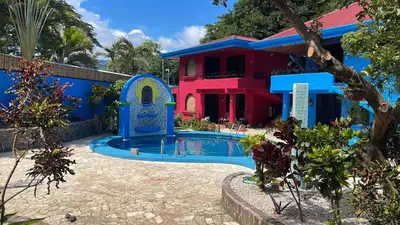 a house with a swimming pool in front of a house at Hotel Carmen Costa Coral in Tambor