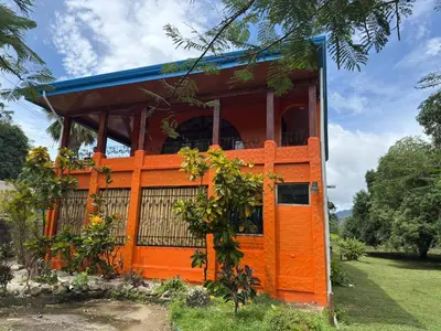 an orange house with a blue roof at Hotel Carmen Costa Coral in Tambor