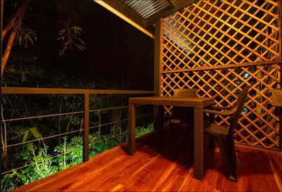 a small table and a chair on a porch at Cabinas La Fulanita in Nicoya