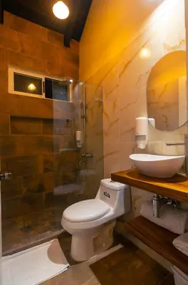 a bathroom with a toilet and a sink and a shower at Cabinas La Fulanita in Nicoya