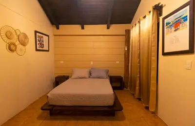a bedroom with a bed in the middle of a room at Cabinas La Fulanita in Nicoya