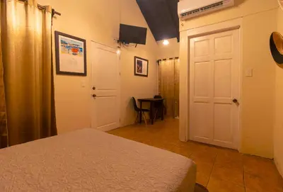 a bedroom with a bed and a white door at Cabinas La Fulanita in Nicoya