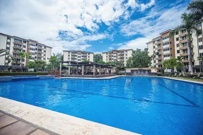 a large blue swimming pool with buildings in the background at 9-26 Costa Linda Jacó Beach pool view Balcony in Jacó