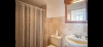 a bathroom with a sink and a toilet and a mirror at 9-26 Costa Linda Jacó Beach pool view Balcony in Jacó