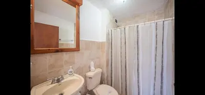 a bathroom with a sink and a toilet and a mirror at 9-26 Costa Linda Jacó Beach pool view Balcony in Jacó