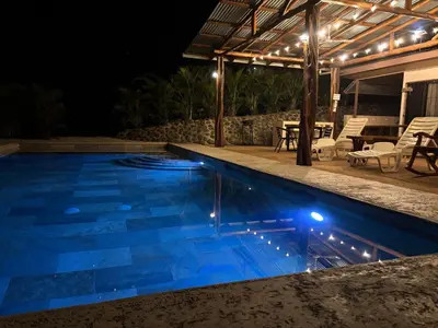 a swimming pool at night with lights on it at Casa el Silencio in Arbolito