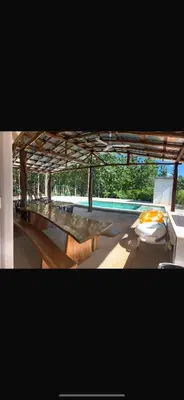 a group of tables in a building with a pool at Casa el Silencio in Arbolito
