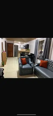 a living room with two couches and a kitchen at Casa el Silencio in Arbolito