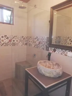 a bathroom with a sink and a mirror at Coyaba Tropical Elegant Adult Guesthouse in Manuel Antonio