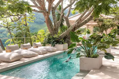 a swimming pool with pillows and plants on it at The Retreat Costa Rica - Wellness Resort & Spa in Atenas
