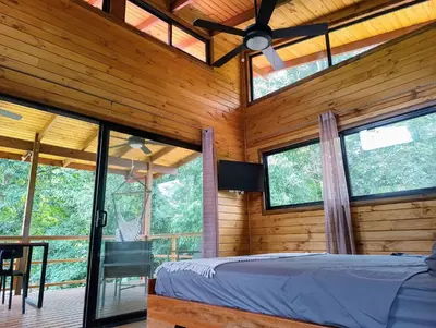 a bedroom in a log cabin with windows and a bed at Thoas Lodge in Coronado