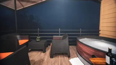 a room with a tub and chairs and a table at Valle Arenal in Fortuna