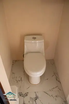a white toilet in a bathroom with a marble floor at Valle Arenal in Fortuna