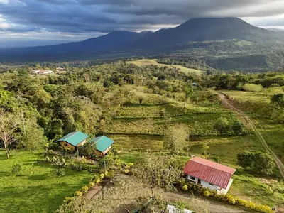 an overhead view of a farm with mountains in the background at Valle Arenal in Fortuna