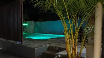 a swimming pool at night with a green illumination at Casa Leona in Quepos