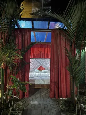 a bedroom with a bed in a room with plants at Casa Leona in Quepos