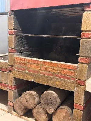 a stack of logs in a brick oven at Casa Leona in Quepos