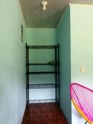 a room with a green wall with a black shelf at Paz y Flora Cabins - 4x4 or 4x2 Car Only in Drake