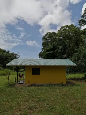 a small yellow house with a green roof at Paz y Flora Cabins - 4x4 or 4x2 Car Only in Drake