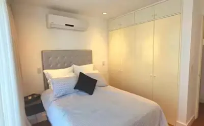 a bedroom with a bed with a laptop on it at Lujo al atardecer en Rohrmoser in San José