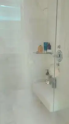 a bathroom with a shower with a glass door at Lujo al atardecer en Rohrmoser in San José