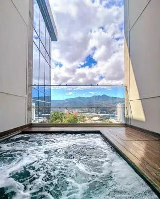 a jacuzzi tub in a building with a view at Lujo al atardecer en Rohrmoser in San José