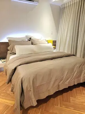 a large bed in a bedroom with a wooden floor at Lujo al atardecer en Rohrmoser in San José
