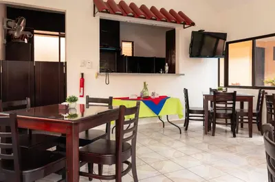 a dining room with a table and chairs at Brisas del Aeropuerto Airport Breezes inn in Heredia
