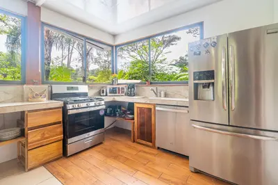 a large kitchen with stainless steel appliances and windows at La Maison de Vénus in Tortugal