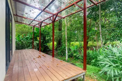 a porch with a wooden deck with a pergola at La Maison de Vénus in Tortugal