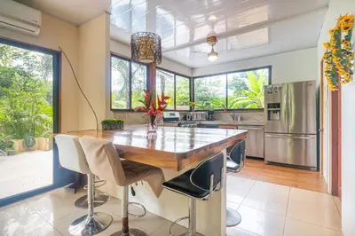 a kitchen with a wooden table and a refrigerator at La Maison de Vénus in Tortugal