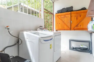 a laundry room with a washing machine and a window at La Maison de Vénus in Tortugal