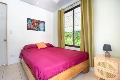 a bedroom with a large bed and a window at La Maison de Vénus in Tortugal