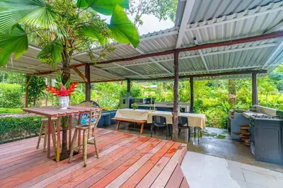 a patio with a wooden deck with a pergola at La Maison de Vénus in Tortugal