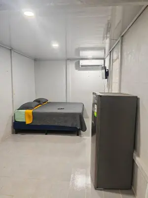 a room with a bed and a refrigerator in it at Apartamento Roxana in San Pedro