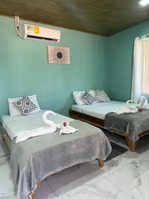 two beds in a room with blue walls at cabina DiTi 2 in Santa Cruz