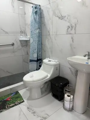 a white bathroom with a toilet and a sink at cabina DiTi 2 in Santa Cruz