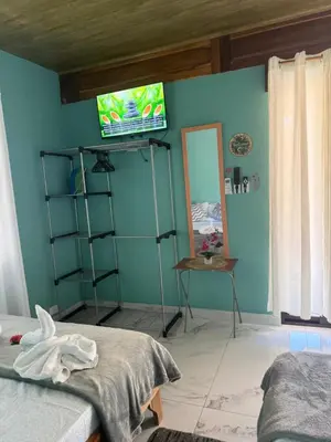 a bedroom with a blue wall with a tv on the wall at cabina DiTi 2 in Santa Cruz