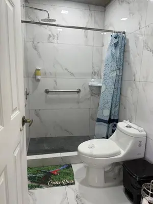 a white bathroom with a toilet and a shower at cabina DiTi 2 in Santa Cruz